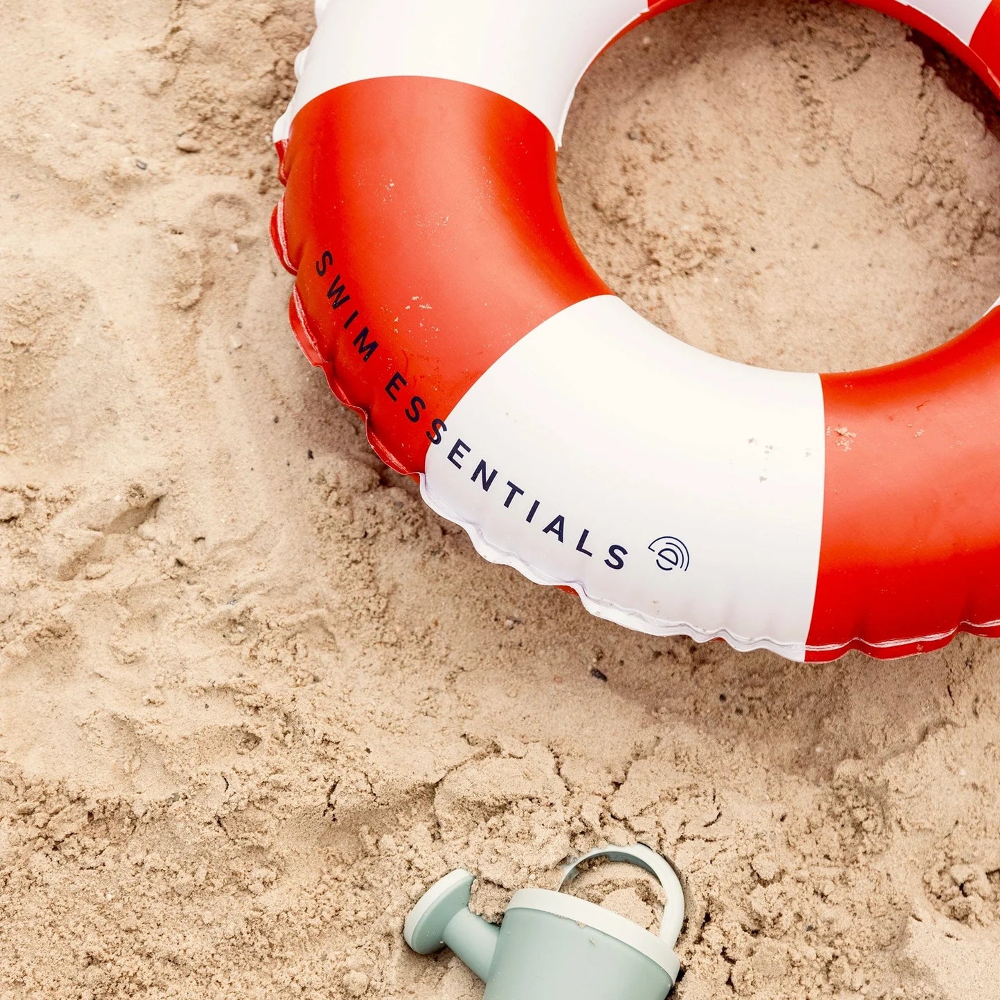 Ciambella Life Buoy Swim Essentials nella sabbia in spiaggia – dettaglio logo