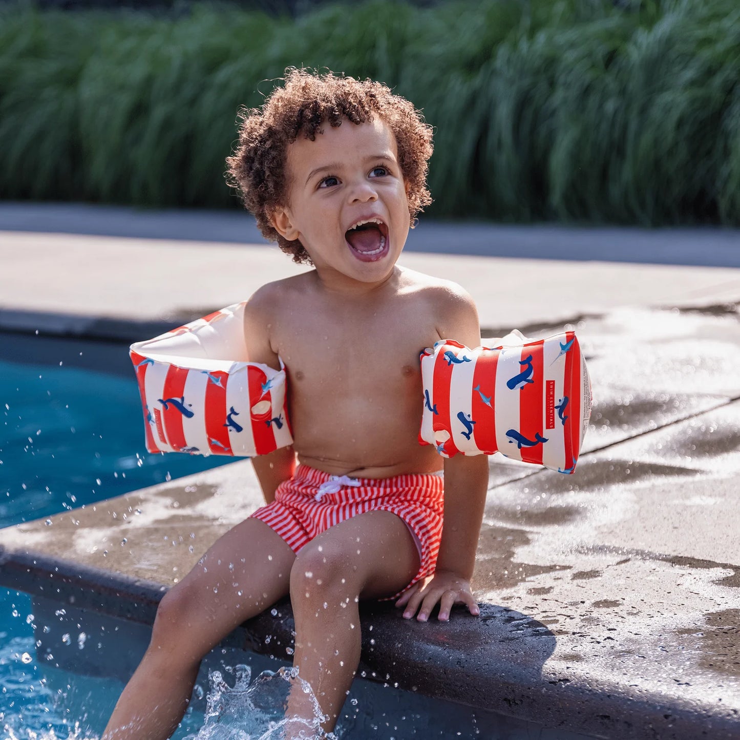Bambino con braccioli Red White Whale in piscina