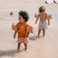 Bambini con braccioli stelle marine in spiaggia