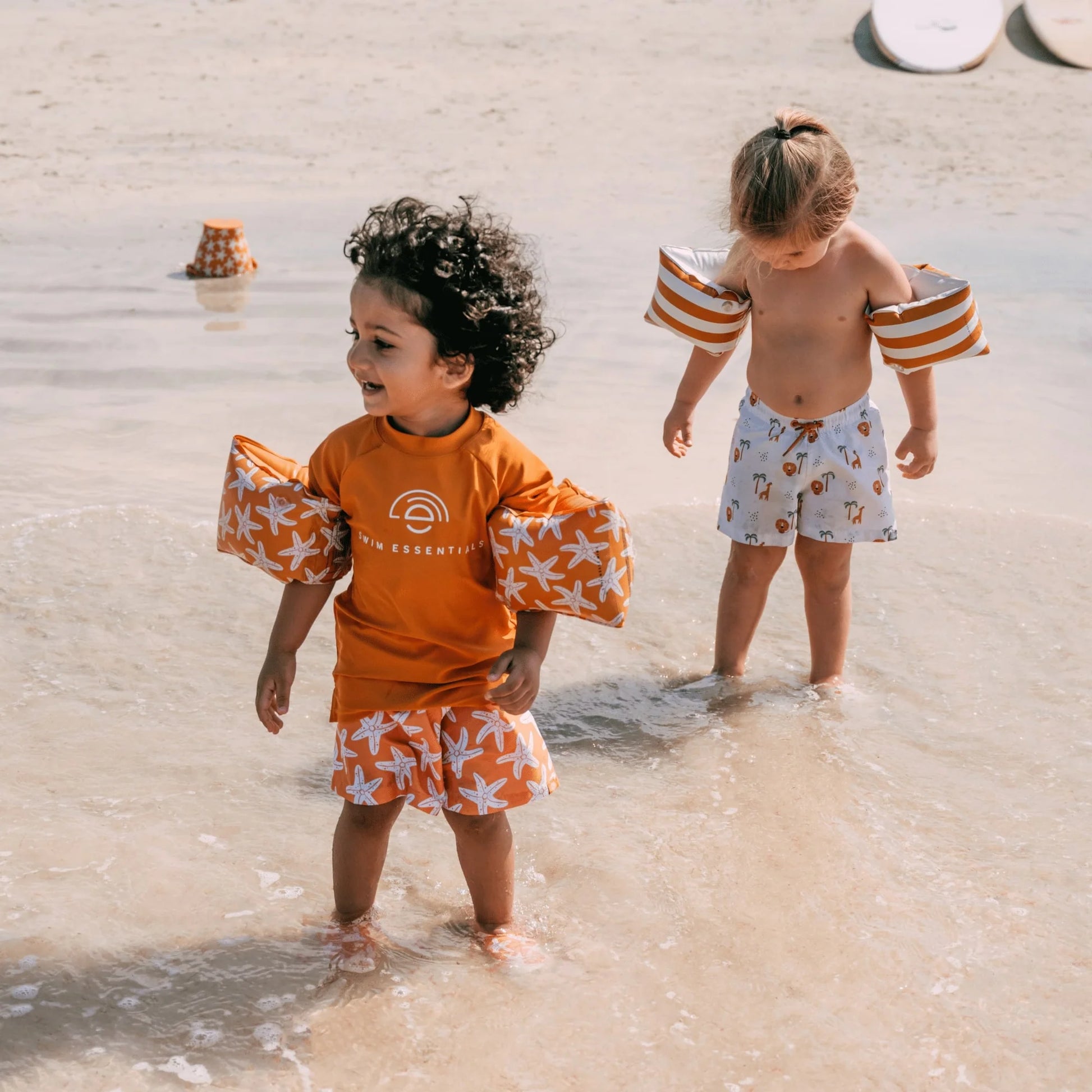 Bambini con braccioli stelle marine in spiaggia