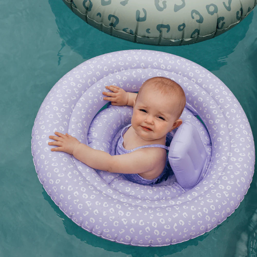 Neonato sorridente con ciambella Lila Leopard in piscina