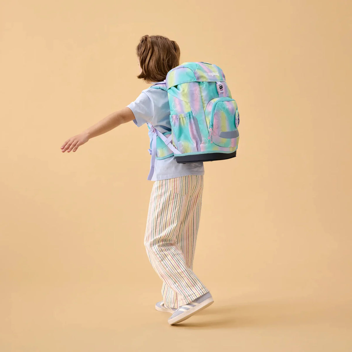 Set Zaino Magic BubbleBear Ergobag indossato da bambina, vista posteriore in movimento