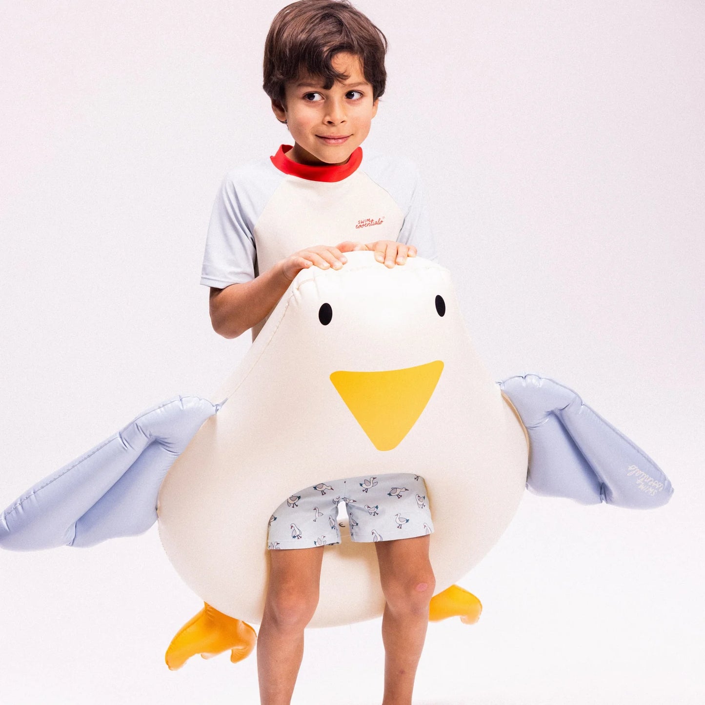 Bambino con ciambella Gabbiano Swim Essentials su sfondo grigio chiaro