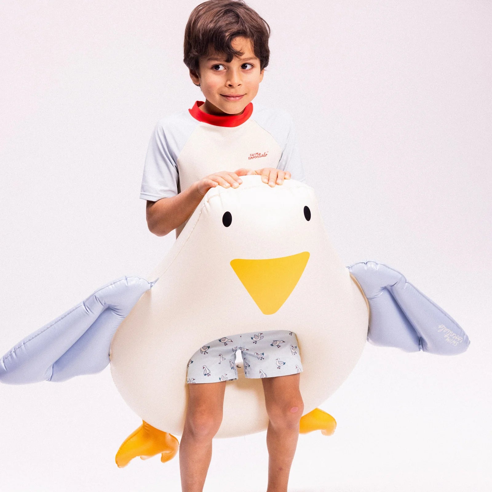 Bambino con ciambella Gabbiano Swim Essentials su sfondo grigio chiaro