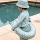 Bambino con ciambella Green Leopard in braccio vicino alla piscina