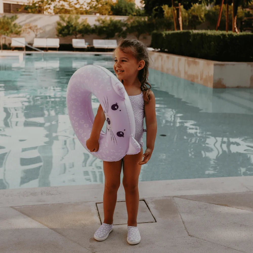 Bambina sorridente con ciambella Lila Leopard in piscina