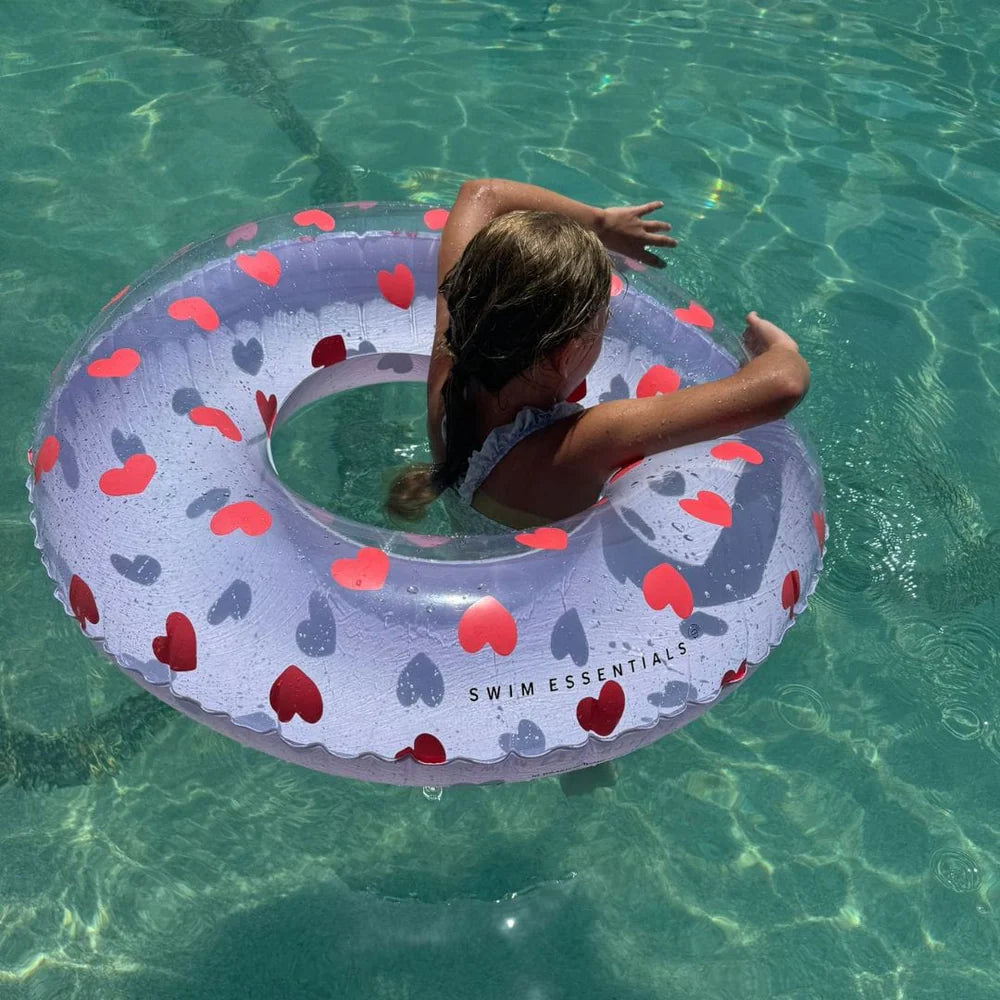Bambina con ciambella Sweet Hearts in piscina – vista dall'alto