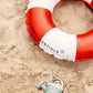 Ciambella Life Buoy Swim Essentials nella sabbia in spiaggia – dettaglio logo