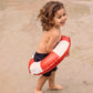 Bambino sorridente con ciambella Life Buoy in spiaggia