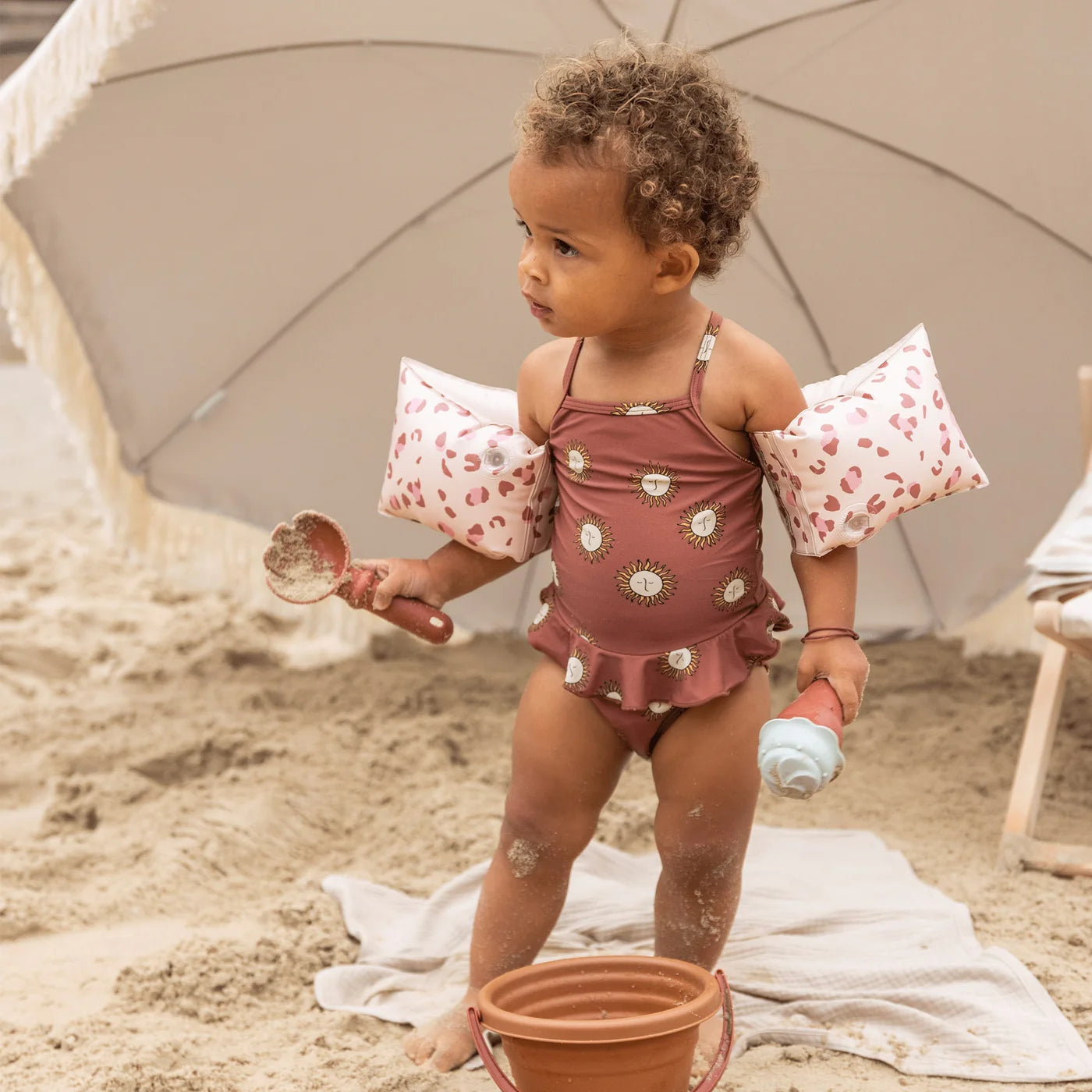 Bambina con braccioli Old Pink Leopard in spiaggia